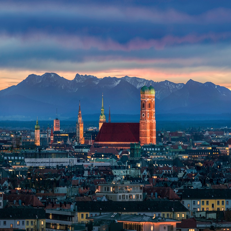Munich at dusk - Mountains of German Alps behind Frauenkirche Berlin